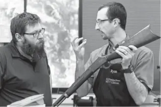  ?? Photos by AAron Ontiveroz, The Denver Post ?? Instructor Ryan Newport, right, talks to student Clinton Hillman about the late 1890s .25-20 rifle Hillman is restoring for a customer during a class called Firearm Restoratio­n I on Feb. 7. Trinidad State Junior College offers an associate of applied science degree in which students learn to design and repair guns.