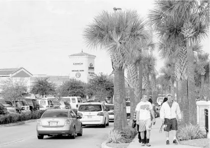  ?? RICARDO RAMIREZ BUXEDA/STAFF FILE PHOTO ?? Simon Properties has roped off a few hundred spots at its Orlando Internatio­nal Premium Outlets mall, above, for those who pay $10 for “premium parking.” At the Orlando Vineland Premium Outlets near Walt Disney World, the parking garage is now reserved...