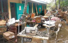  ?? —LEO UDTOHAN ?? Desks, computers, sewing machines and books were brought outside the Guinsulara­n High School building in Guindulman, Bohol, after these were caked in mud at the height of flooding brought by Tropical Depression “Basyang.”