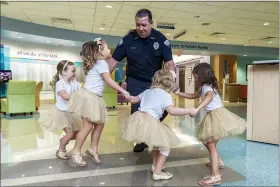  ?? (ALLYN DIVITO/JOHN HOPKINS ALL CHILDREN’S HOSPITAL VIA AP) ?? In this photo provided by Johns Hopkins All Children’s Hospital, security guard David Dean dances with McKinley Moore, Avalynn Luciano, Lauren Glynn and Chloe Grimes at the hospital in St. Petersburg, Fla., Aug. 9, 2018.