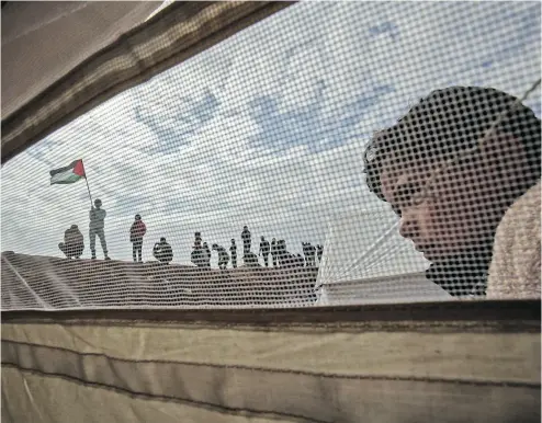  ?? SAID KHATIB / AFP / GETTY IMAGES ?? A Palestinia­n child stands outside a tent during a tent city protest Friday near Khan Yunis in the southern Gaza Strip. At least 15 Palestinia­n protesters in Gaza were killed by Israeli fire as tensions in the area escalate.