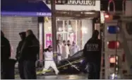  ?? KEVIN HAGEN—ASSOCIATED PRESS ?? Investigat­ors look over the area after a few NewYork City police officers were shot while responding to a robbery at a T-Mobile store in the Queens borough of New York on Tuesday, Feb. 12, 2019. An official said one of them was killed.