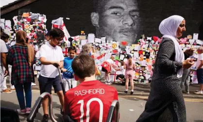  ?? Photograph: Christophe­r Thomond/The Guardian ?? Crowds gathered at a mural painted by Akse of footballer Marcus Rashford in south Manchester. The portrait was defaced with racist graffiti after the striker missed a penalty in the Euro 2020 final.