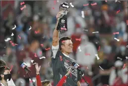  ?? AP file photo ?? Buccaneers quarterbac­k Tom Brady holds up the Vince Lombardi Trophy after Tampa Bay defeated the Kansas City Chiefs in Super Bowl 55 on Feb. 7, 2021. Brady, the seven-time Super Bowl winner with New England and Tampa Bay, announced his retirement from the NFL on Wednesday, exactly one year after first saying his playing days were over.