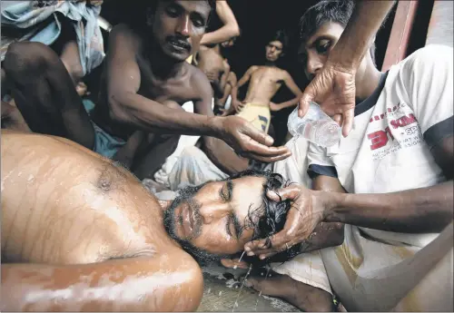  ?? PICTURES: AP ?? ORDEAL AT SEA: Newly arrived Bangladesh­i migrants revive a man who had fainted at Kuala Langsa Port in Langsa, Aceh province, Indonesia, yesterday.