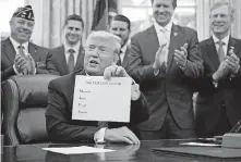  ?? [MANUEL BALCE CENETA/ASSOCIATED PRESS FILE PHOTO] ?? President Donald Trump holds a sheet of paper with the names of four U.S. companies worth over a trillion dollars Feb. 11 during the Supporting Veterans in STEM Careers Act signing ceremony in the Oval Office at the White House in Washington. He noted that the first letters of the companies spells “MAGA” (Make America Great Again).