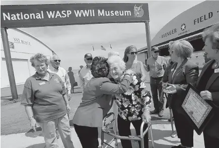  ?? Ronald W. Erdrich/The Abilene Reporter-News via AP ?? Jessie Lou McReynolds is hugged by Jeanne Brewer after the dedication and ribbon-cutting of the new Hangar No. 1 on May 25 at Avenger Field in Sweetwater, Texas. The building is a replica of the original hangar, which trained the Women Airforce Service...