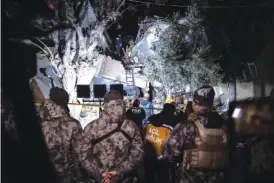  ?? UGUR YILDIRIM/DIA VIA AP ?? On Monday, rescue team members search for people in a destroyed building during the aftermath of an earthquake in Hatay, Turkey.