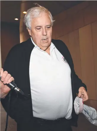  ??  ?? Clive Palmer holds a sick bag as he arrives at the Federal Court after a lunch break in Brisbane.