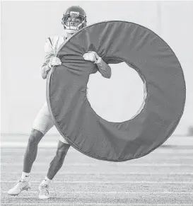  ?? Brett Coomer / Houston Chronicle ?? Texans cornerback Kevin Johnson isn’t getting in the Olympic spirit; he’s merely trying to handle a tackling ring during a drill Monday.