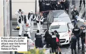  ??  ?? Police officers gather in the area of a knife attack near the former offices of Charlie Hebdo in Paris