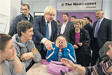  ??  ?? Boris Johnson turns on the charm as he visits an indoor market in Newport, south Wales, with the local Conservati­ve candidate Angela Jones-evans, second from right