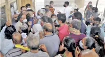  ??  ?? People argue with a security guard after stocks got over at a vaccinatio­n centre in Ahmedabad, on Sunday