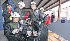  ?? FOTO: A. TINTER ?? Kinder üben im Raphaelsha­us den Reifenwech­sel wie bei der Formel 1. Handwerkli­che Fähigkeite­n kamen ihnen auch beim „Projekt Heimat“zugute.
