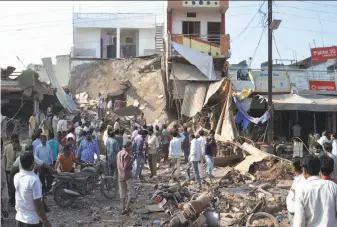  ?? Manoj Jani / Associated Press ?? A crowd gathers at the site of the explosions in Petlawad, in the central Indian state of Madhya Pradesh. A cooking gas cylinder exploded and caused a second blast of mine detonators.