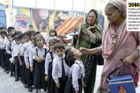  ??  ?? 2016 A Lahore, au Pakistan. A l’occasion de la Journée mondiale contre la Polio, le 24 octobre, des travailleu­rs sociaux administre­nt le vaccin aux enfants.