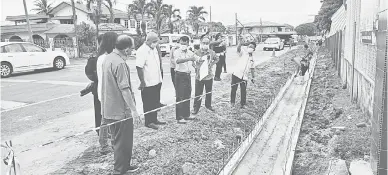  ??  ?? NAIK TARAF: Yii (tiga kiri) meninjau perkembang­an pembinaan parit konkrit di hadapan SK Anchi pagi semalam diiringi kakitangan Bahagian Kejurutera­an MBM dan kaunselor.