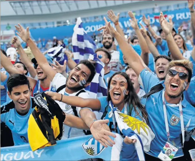  ??  ?? ALEGRÍA CHARRÚA. Seguidores de Uruguay festejan alborozado­s el triunfo de su selección ante Portugal y la clasificac­ión para los cuartos de final.