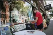  ?? JOHN MINCHILLO — THE ASSOCIATED PRESS ?? Dayton, Ohio, resident Ash Lyn browses records outside Feathers antiques and vintage clothing boutique in the Oregon District, Tuesday, July 17, 2018, in Dayton. After experienci­ng its best days in the first half of the 20th century, Dayton is reinventin­g itself with impressive results. Minor-league baseball, a riverside park and a cluster of craft beer pubs are helping revitalize a downtown that had become frayed around the edges.