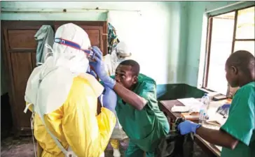  ?? UNICEF/AFP ?? Health workers put on protective gear as they prepare to attend to suspected Ebola patients at Bikoro Hospital - the epicentre of the latest Ebola outbreak in the Democratic Republic of Congo – on May 12.