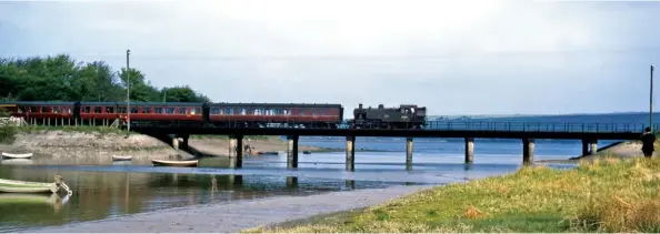  ?? R Patterson/Colour-Rail.com/315721 ?? The tide is partially in at Fremington Pill as BR-built Ivatt ‘2MT’ 2-6-2T No 41283 crosses the water on approach to the station with a service from Torrington to Barnstaple Junction on Sunday, 3 May 1964. The train will connect with an Ilfracombe to Exeter service at Barnstaple Junction. These engines displaced the last remaining Drummond ‘M7s’ in the West Country shortly after the Western Region gained full control of the former SR lines west of Wilton in early 1963. However, despite this being an LMS-designed engine hauling former GWR stock, it was not until the start of the winter 1964 timetable that the new order began dismantlin­g the carefully honed timetable of through coaches and well-timed connecting services.