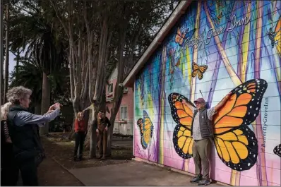  ?? (File Photo/AP/Nic Coury) ?? Leslee Russell of Livermore, Calif., takes a picture of her husband Dave Russell in front of a mural Nov. 10, 2021, outside the Butterfly Grove Inn near the Monarch Grove Sanctuary.