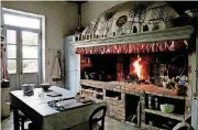  ??  ?? A dinnertime fire burns in Lulu Peyraud’s legendary woodburnin­g kitchen hearth, the inspiratio­n behind a similar cooking hearth in the home of Alice Waters.