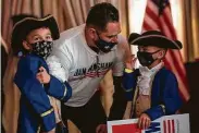  ?? Brett Coomer / Staff photograph­er ?? Randy Ruiz huddles with his sons Jaylen and Jayse as they wait for U.S. Rep. Dan Crenshaw to take the stage.