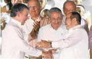  ?? LUIS ACOSTA/GETTY IMAGES ?? Colombian President Juan Manuel Santos, left, and the leader of the FARC, Rodrigo Londono, right, better known as Timoleon “Timochenko” Jimenez, congratula­te each other as Cuban President Raul Castro looks on after the signing of the historic peace...