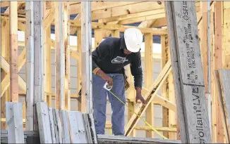  ?? LM OTERO / ASSOCIATED PRESS 2014 ?? A constructi­on worker does some measuring before cutting a frame in December at a house being built in Coppell. Housing and constructi­on are rebounding, leading experts to predict that while the first quarter likely was weak, the U.S. economy will post...