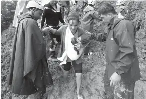  ?? Jayjay Landingin/Associated Press ?? ■ Rescuers assist a mother and her child Sunday as they evacuate to safer grounds following landslides that hit Itogon township, Benguet province, in the northern Philippine­s. The landslides buried dozens of miners and isolated the township. Typhoon Mangkhut barreled into southern China on Sunday after lashing the northern Philippine­s with strong winds and heavy rain that left dozens dead from landslides and drownings.