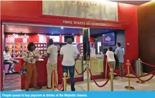  ??  ?? People queue to buy popcorn or drinks at the Majestic cinema.