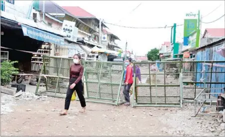  ?? HENG CHIVOAN ?? Women walk through barricades in Chaom Chao commune in Phnom Penh’s Por Sen Chey district on May 26.