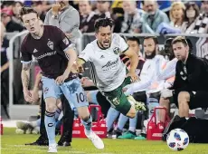  ?? THE ASSOCIATED PRESS ?? Colorado forward Joe Mason tangles with Portland Timbers midfielder Sebastian Blanco last Saturday. The Rapids have lost six straight games and sit last in the Western Conference.