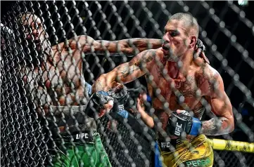  ?? AP ?? Brazil’s Alex Pereira, right, punches New Zealand’s Israel Adesanya during their middleweig­ht bout at the UFC 281 event in New York. Pereira stopped Adesanya in the fifth round.