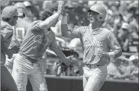  ?? Associated Press ?? Big run: North Carolina's Michael Busch (15) is greeted by Brandon Riley after scoring on a fly ball by Riley in the third inning against Oregon State in Omaha, Neb.