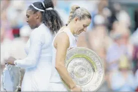  ?? Nic Bothma / Pool via AP ?? Angelique Kerber, right, holds her trophy and walks past Serena Williams after defeating the seven-time champ in the women’s final.