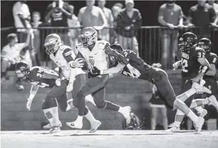  ?? PHOTOS BY MARK GILLILAND ?? Notre Dame’s Cameron Wynn tries to break the tackle of Silverdale Baptist’s Jarrett Clift during Friday’s game. Notre Dame won 58-0.