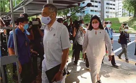  ?? AFP PIC ?? Singapore’s Prime Minister Lee Hsien Loong (left) arriving at the nomination centre ahead of next month’s general election in Singapore yesterday.