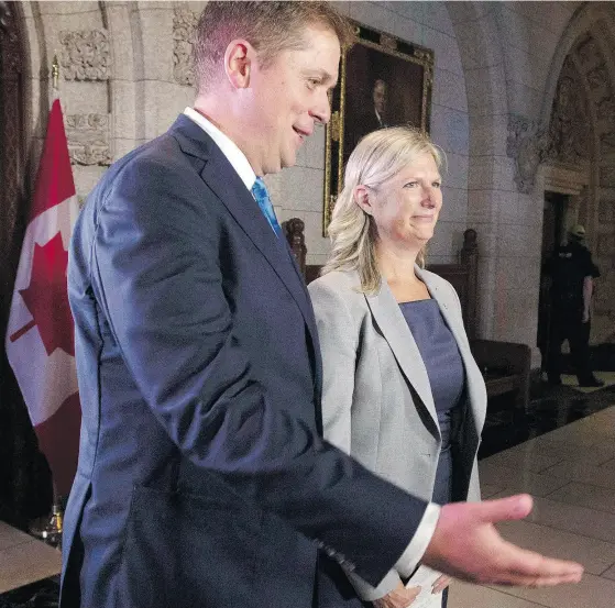  ?? ADRIAN WYLD / THE CANADIAN PRESS ?? Leader of the Opposition Andrew Scheer gestures to MP Leona Alleslev to deliver a statement to the media after announcing she would cross the floor from the Liberals to the Conservati­ves Monday on Parliament Hill.