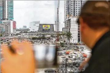  ?? GREG LOVETT / THE PALM BEACH POST ?? Matthew Litwin of Jupiter Farms views AmericanAi­rlines Arena through a train window Saturday as Brightline pulls up to the Miami station on the first day of service from West Palm Beach to Miami.