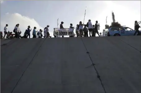  ?? ERIC GAY — THE ASSOCIATED PRESS ?? Hundreds of people march along a levee in south Texas on Saturday toward the Rio Grande to oppose a wall the U.S. government wants to build on the river separating Texas and Mexico in Mission, Texas. The area would be the site of new barrier.