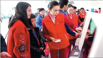  ?? PHOTOS PROVIDED TO CHINA DAILY ?? Employees of China Southern Airlines help passengers use the airline’s online seat selection service.