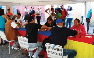  ?? (Marco Bello/Reuters) ?? PEOPLE SIGN IN at a polling station in Caracas yesterday during an unofficial plebiscite against Venezuelan President Nicolas Maduro and his plan to rewrite the country’s constituti­on.