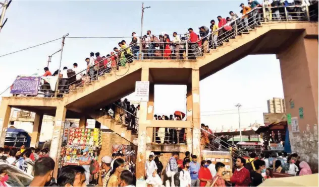  ?? Agence France-presse ?? ↑
People crowd at a bus station before a week-long lockdown comes into effect in New Delhi on Monday.