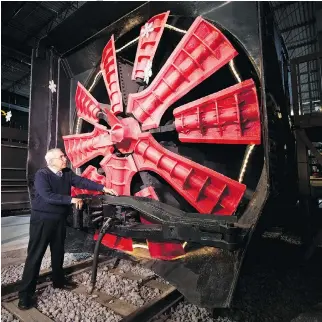  ??  ?? Exporail volunteer Alain St. Pierre explains how a rotary snowplow works. The plows were expensive to operate, and most models are now in rail museums. But the technology led to the invention of the world’s first snowblower.