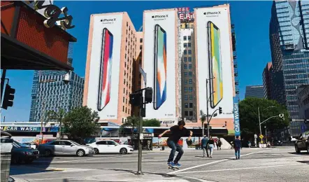  ?? — AFP ?? New offering: Advertisem­ents for iPhone X covers the sides of buildings in Los Angeles. Facing disappoint­ing iPhone 8 and iPhone 8 Plus sales, Apple pins its hopes on iPhone X, which is more innovative but less profitable.