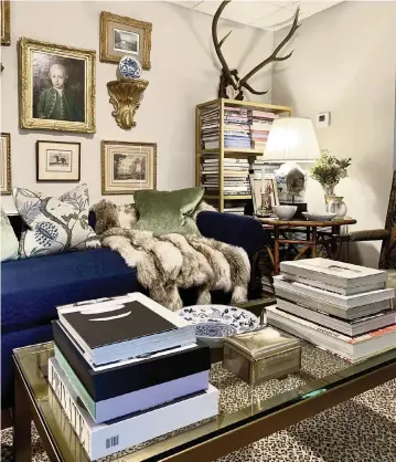  ?? PHOTOS BY PATRICIA SHERIDAN Pittsburgh Post-Gazette/TNS ?? The brass and glass coffee table holds favorite books while allowing the leopard rug to make its presence known in Jim Miller's chic and charming home. Scottish roebuck antlers draw the eye up and add height.