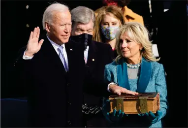  ?? AP PHOTO BY ANDREW HARNIK ?? Joe Biden is sworn in as the 46th president of the United States by Chief Justice John Roberts as Jill Biden holds the Bible during the 59th Presidenti­al Inaugurati­on at the U.S. Capitol in Washington, Wednesday, Jan. 20.