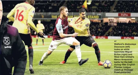  ?? AP ?? Watford's Abdoulaye Doucoure (left) looks on while teammate Miguel Britos (right) and West Ham United's Marco Arnautovic battle for the ball during their English Premier League match at Vicarage Road yesterday.